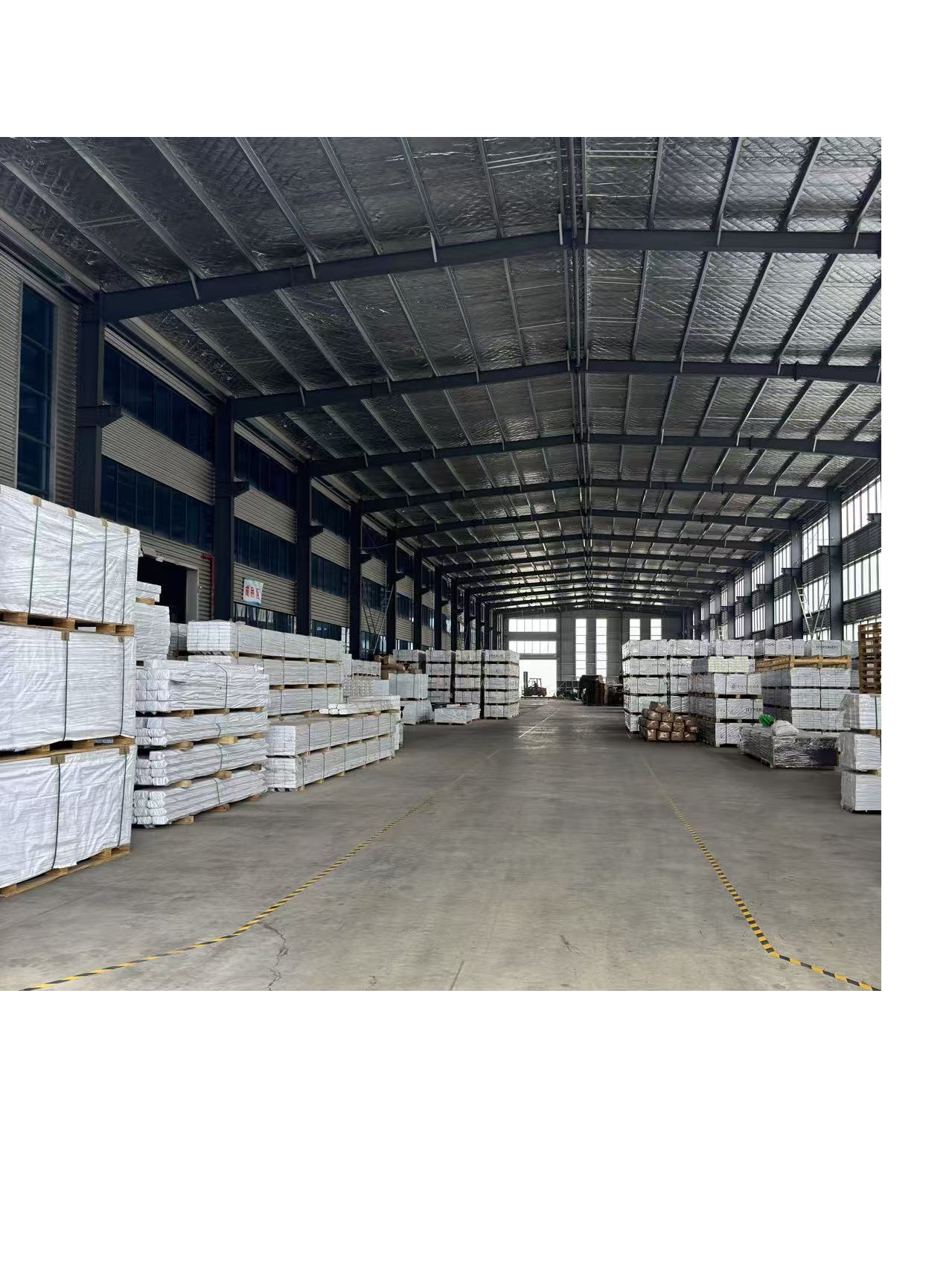 Warehouse storage area with stacked pallets of packaged WPC products ready for shipment